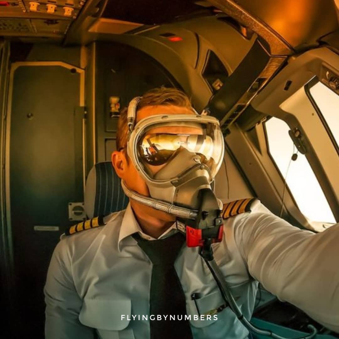Pilot in cockpit wearing full face oxygen mask