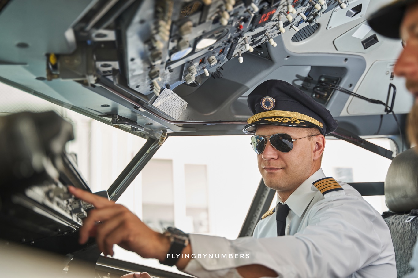 Airline captain with hat turning on flight directors
