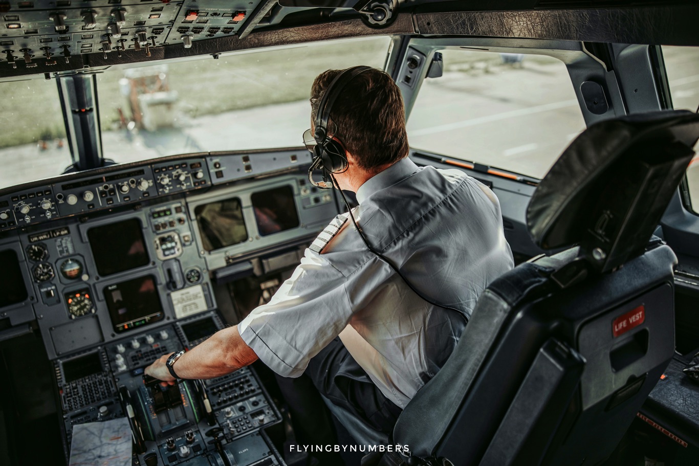Airline pilot with hands on thrust levers on ground